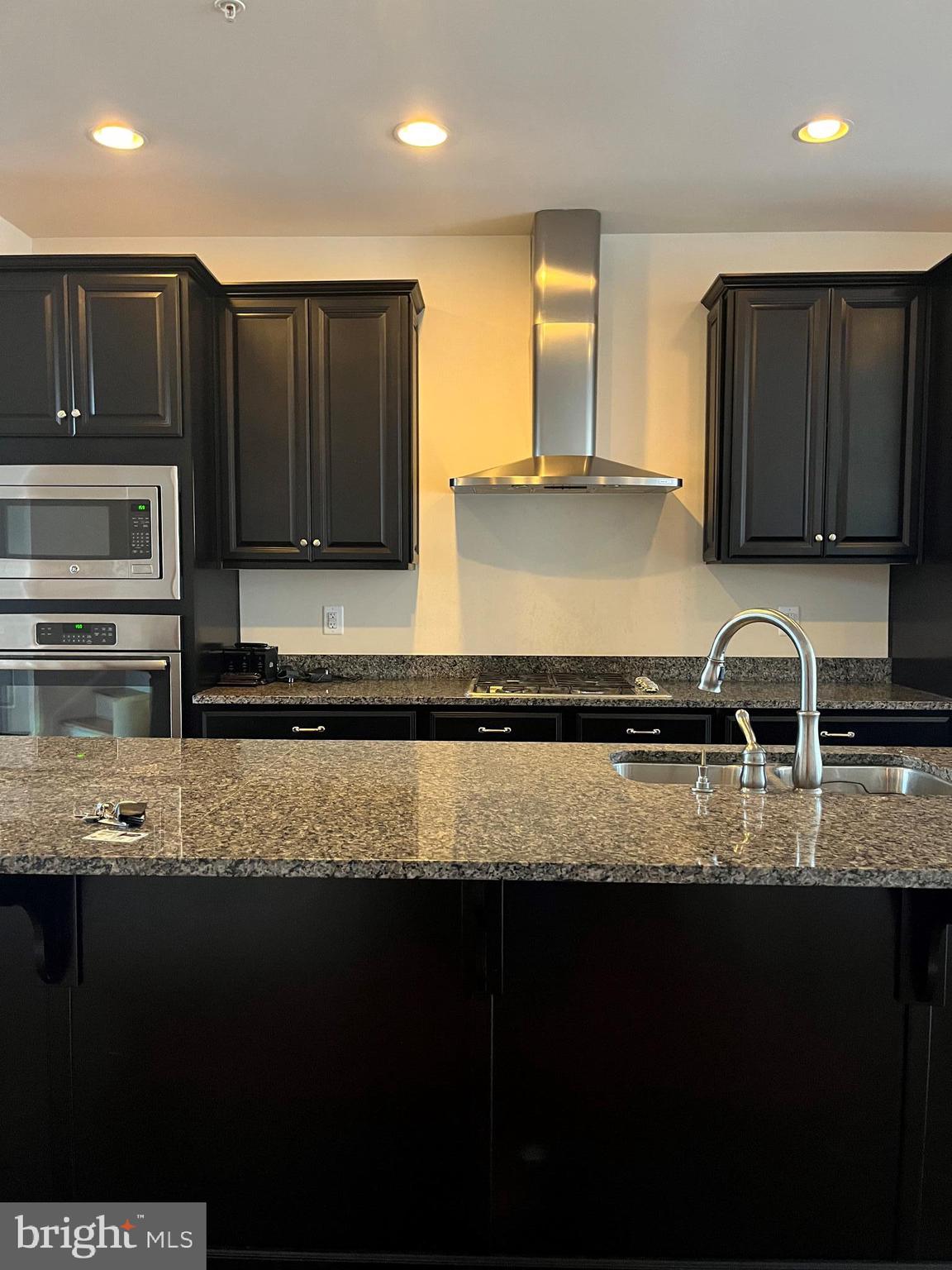 7812 Patterson Way Hanover, MD 21076 - Photo 3 of 15 a kitchen with a sink a stove a microwave and cabinets