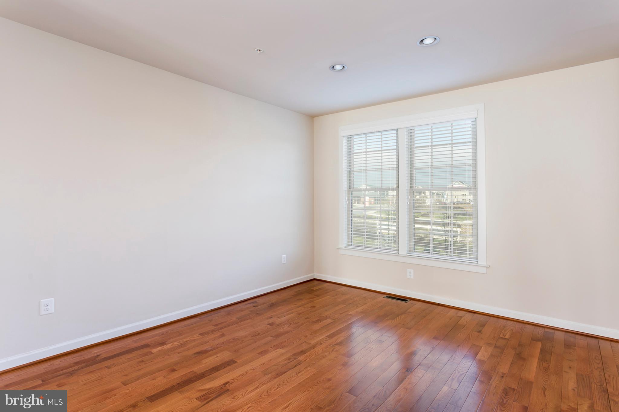 7812 Patterson Way Hanover, MD 21076 - Photo 8 of 15 an empty room with wooden floor and windows