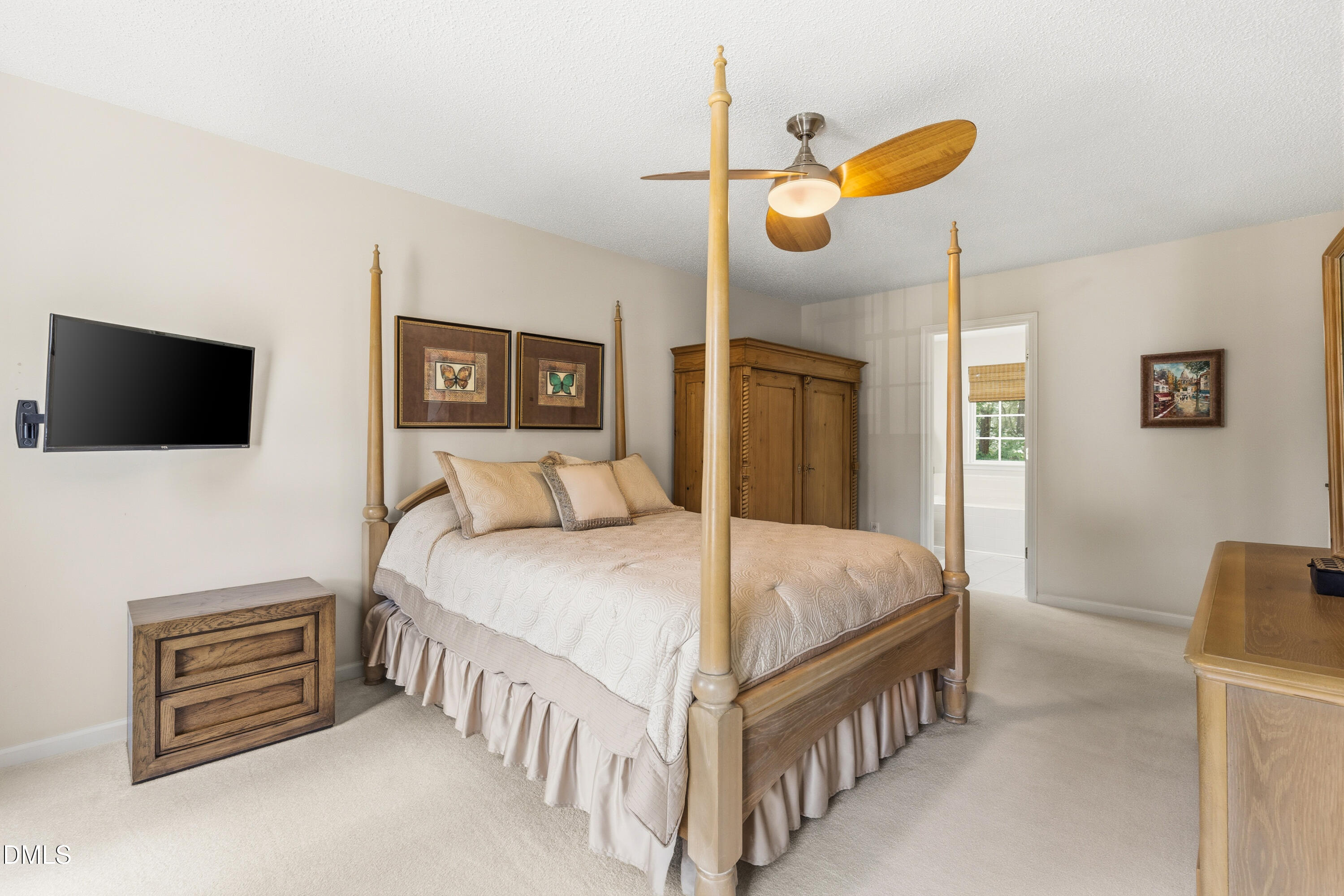 1211 Waterford Green Drive Apex, NC 27502 - Photo 31 of 53 a bedroom with a bed a flat screen tv and a chandelier
