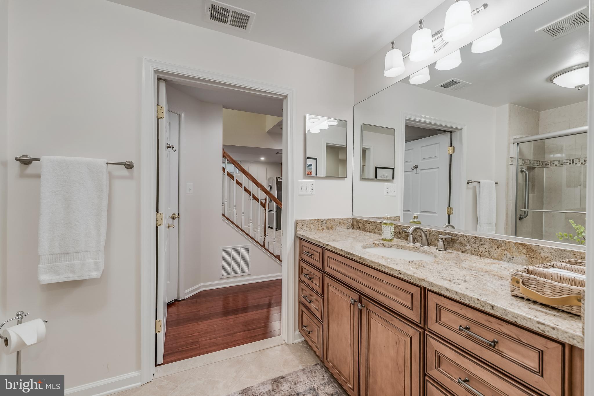 12537 Ridgegate Drive Herndon, VA 20170 - Photo 68 of 80 a bathroom with a granite countertop double vanity sink a mirror and shower