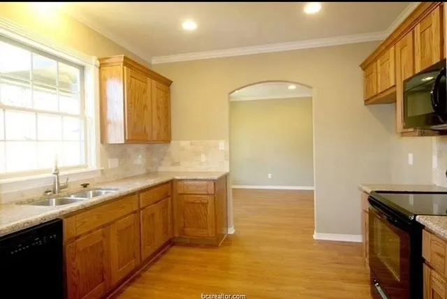 a kitchen with a sink a stove and cabinets