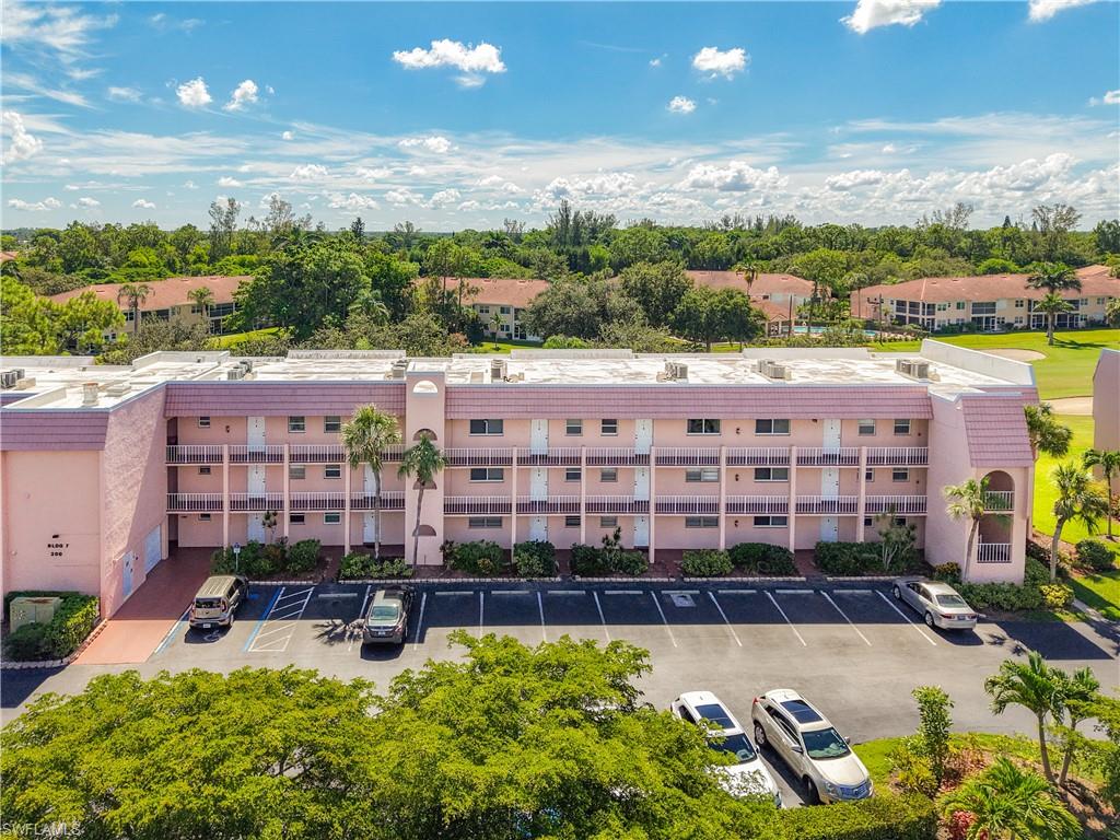 200 Turtle Lake Court, Unit 109 Naples, FL 34105 - Photo 2 of 37 View of apartment building / complex with uncovered parking
