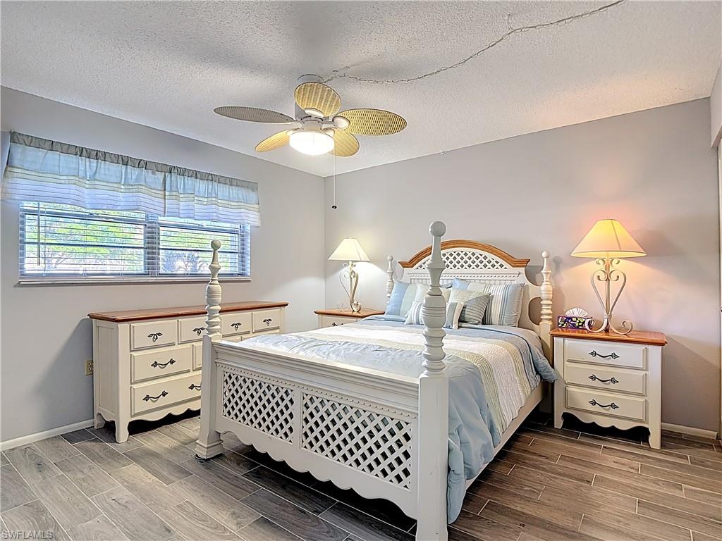 200 Turtle Lake Court, Unit 109 Naples, FL 34105 - Photo 21 of 37 Bedroom featuring wood tiled floors, a textured ceiling, and ceiling fan