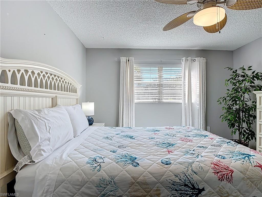 200 Turtle Lake Court, Unit 109 Naples, FL 34105 - Photo 26 of 37 Bedroom featuring a textured ceiling and a ceiling fan
