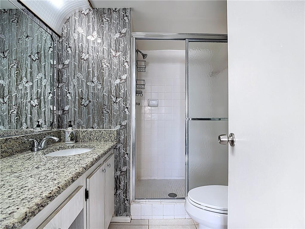 200 Turtle Lake Court, Unit 109 Naples, FL 34105 - Photo 29 of 37 Full bath featuring a shower stall, light tile patterned floors, and vanity