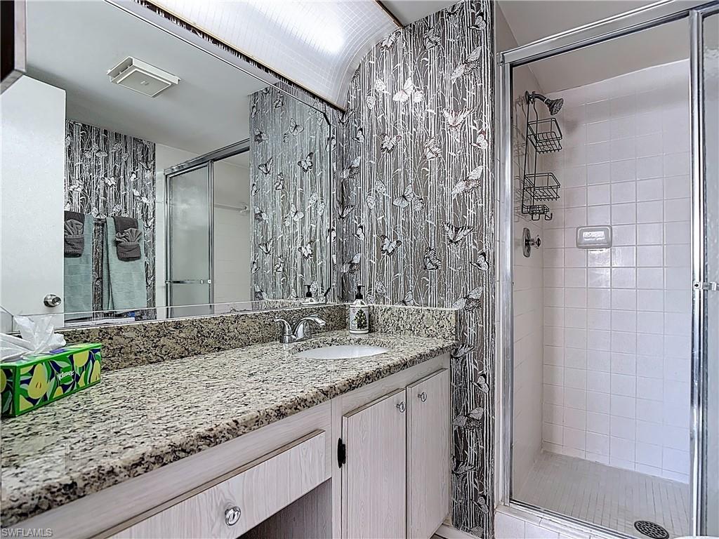 200 Turtle Lake Court, Unit 109 Naples, FL 34105 - Photo 30 of 37 Bathroom with vanity and a shower stall