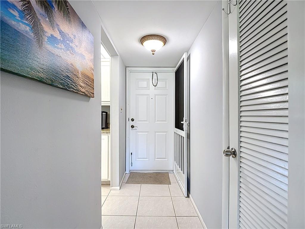 200 Turtle Lake Court, Unit 109 Naples, FL 34105 - Photo 4 of 37 Doorway with tile patterned floors and baseboards
