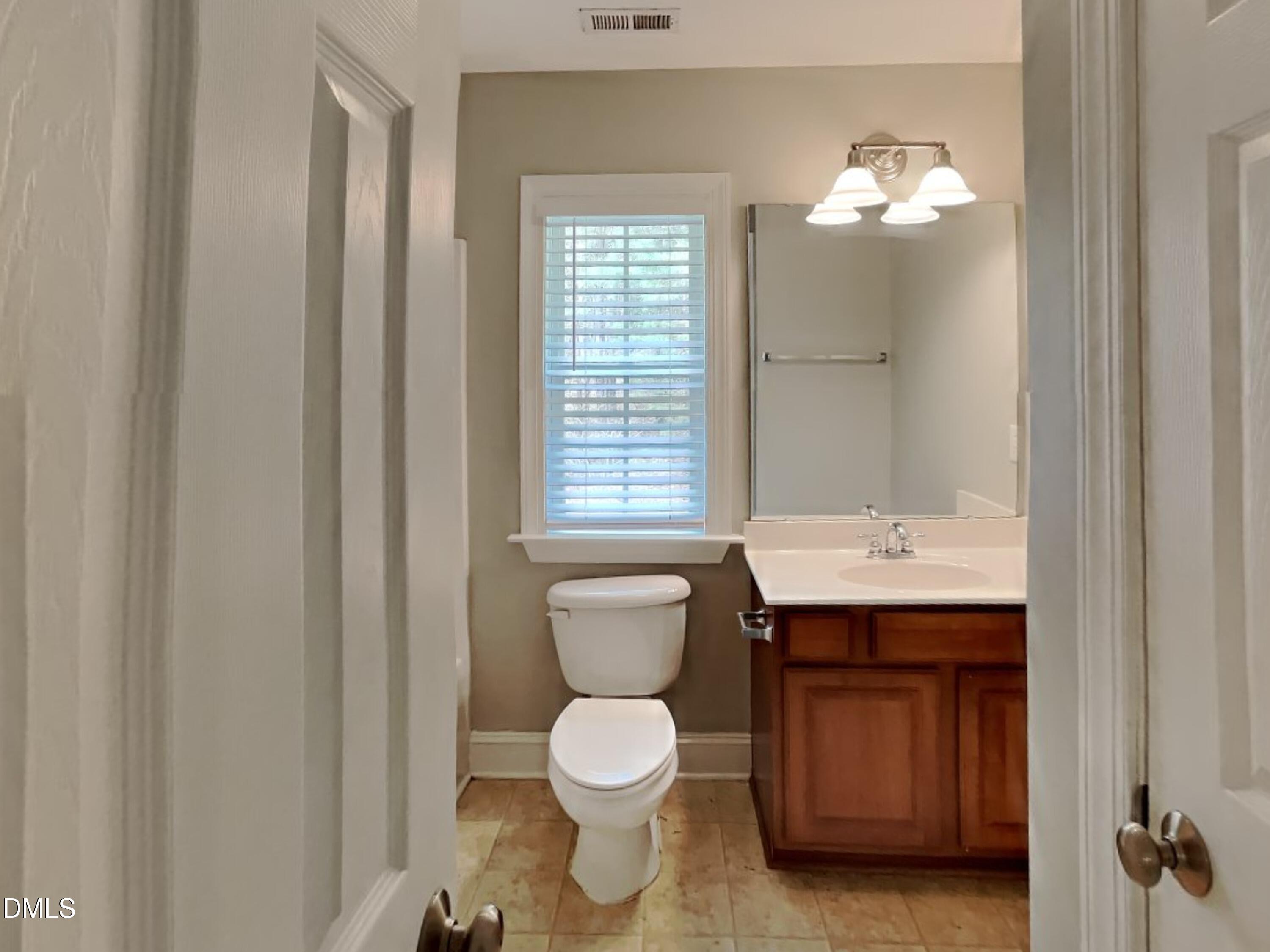 9531 Waterwood Court Raleigh, NC 27614 - Photo 15 of 19 a bathroom with a toilet sink and mirror