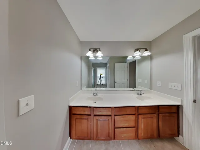 a bathroom with a double vanity sink and a mirror