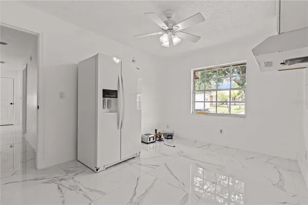 a view of a livingroom with a chandelier fan and windows