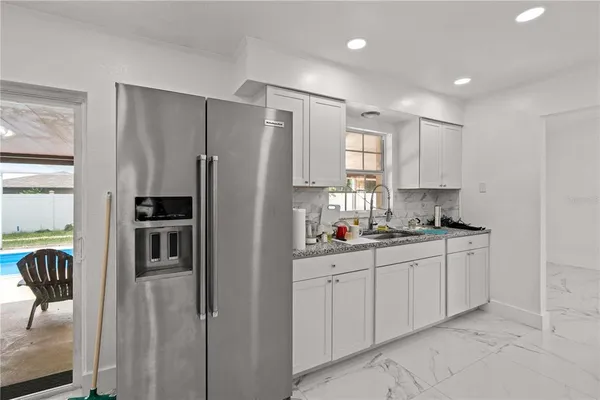 a kitchen with granite countertop a sink stainless steel appliances and cabinets