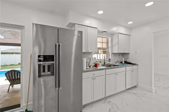 a kitchen with granite countertop a sink stainless steel appliances and cabinets