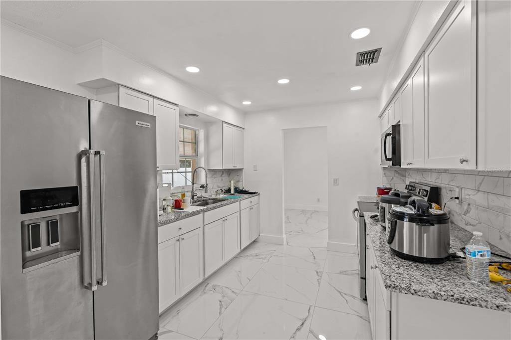 3104 Apricot Street Seffner, FL 33584 - Photo 18 of 31 a kitchen with granite countertop a sink stainless steel appliances and cabinets