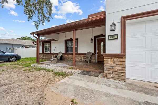 a backyard of a house with barbeque oven and outdoor seating