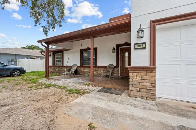 a backyard of a house with barbeque oven and outdoor seating