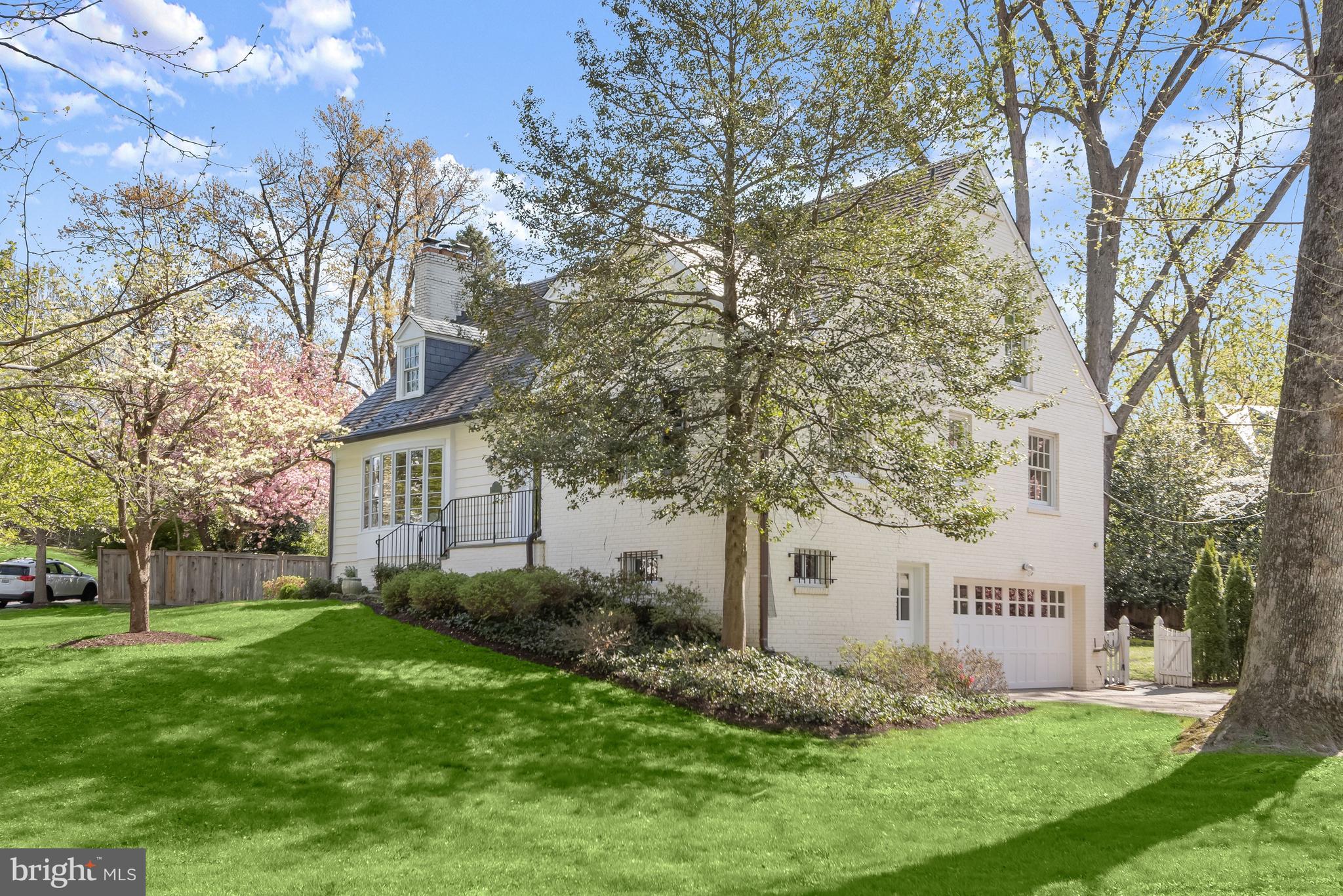 5120 Upton Street Northwest Washington, DC 20016 - Photo 50 of 53 a view of a white house next to a yard with big trees