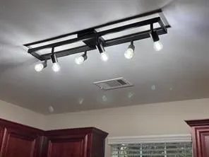 a view of an empty room with chandelier fan and fireplace