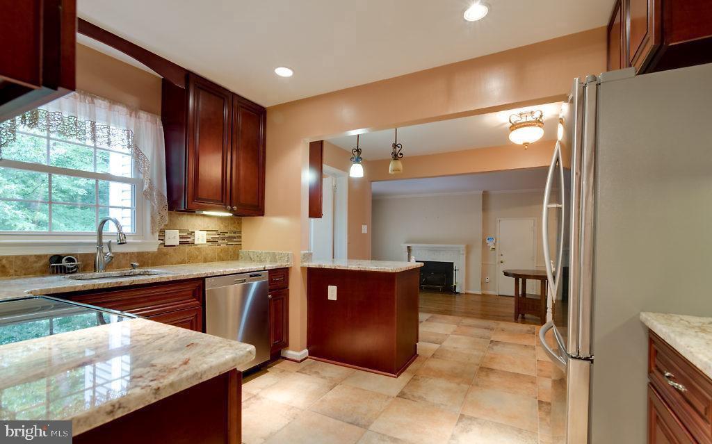 7801 Cliffside Court Springfield, VA 22153 - Photo 15 of 71 a large kitchen with stainless steel appliances granite countertop wooden cabinets a oven and granite counter tops with a large window
