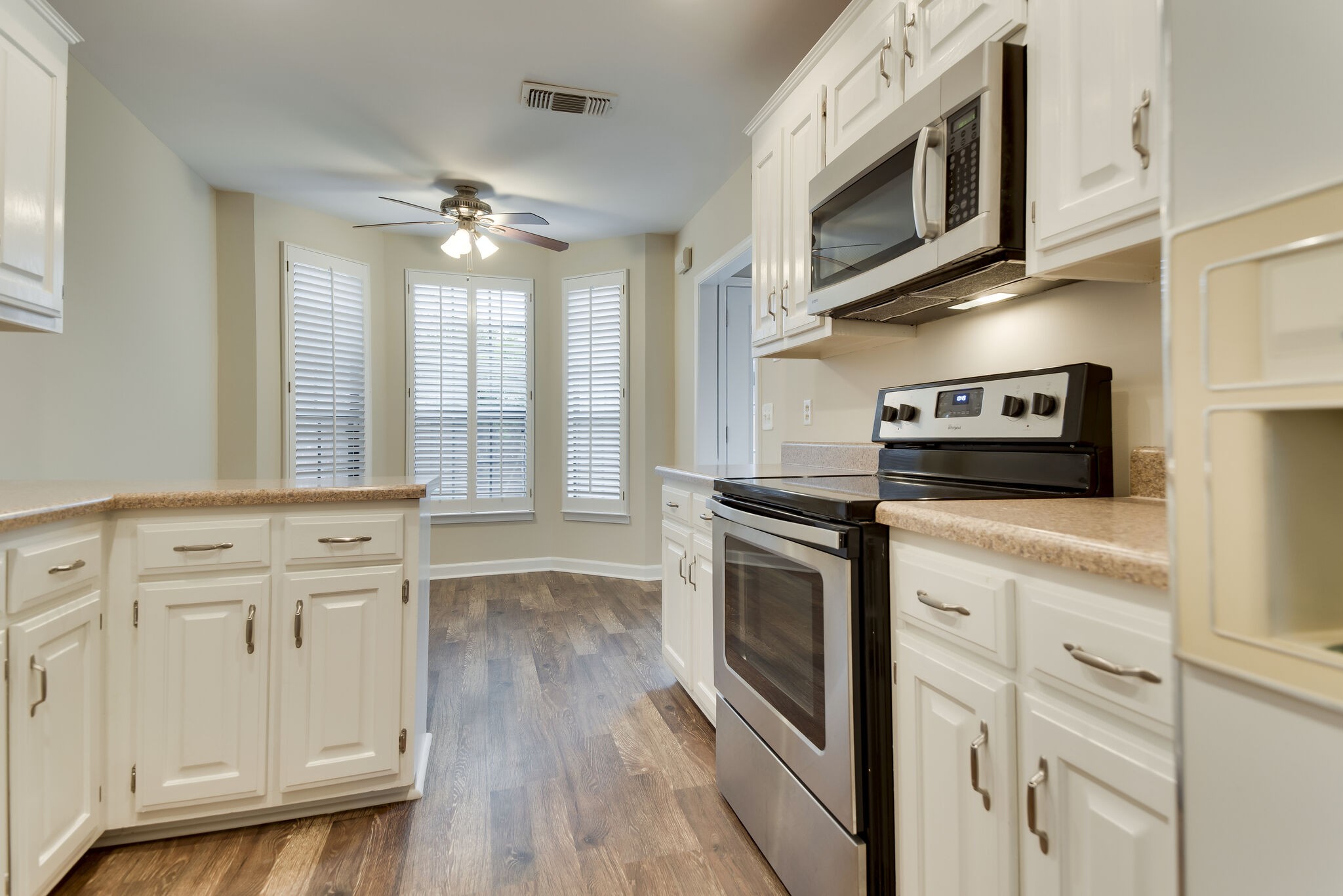 737 General George Patton Road Nashville, TN 37221 - Photo 22 of 36 a kitchen with stainless steel appliances granite countertop a stove a microwave and white cabinets