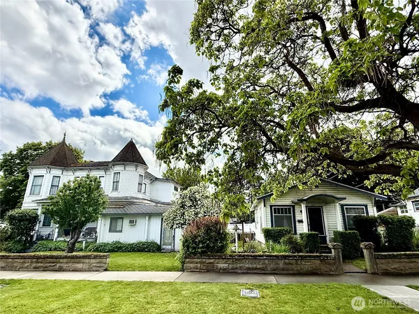 a front view of a house with a yard and potted plants