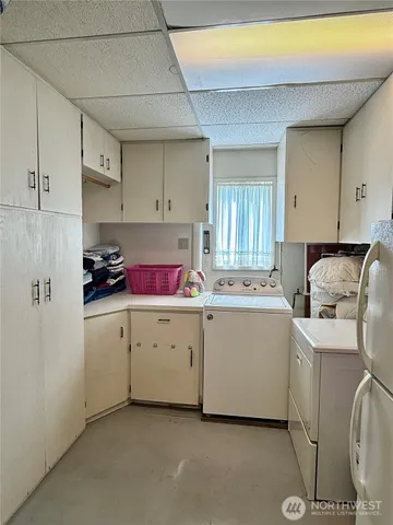 a utility room with cabinets washer and dryer