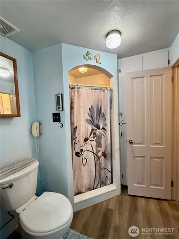 a bathroom with a toilet a sink and mirror