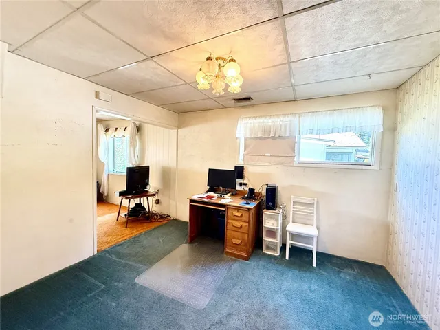 a view of a workspace with furniture and a window