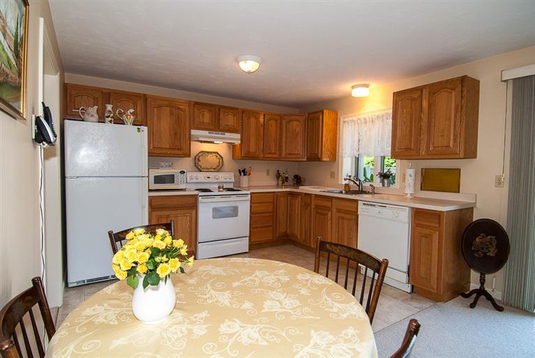 481 Buck Island Road, Unit 15D West Yarmouth, MA 02673 - Photo 6 of 21 a kitchen with refrigerator cabinets and chairs