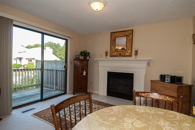 481 Buck Island Road, Unit 15D West Yarmouth, MA 02673 - Photo 7 of 21 a living room with a fireplace and a floor to ceiling window