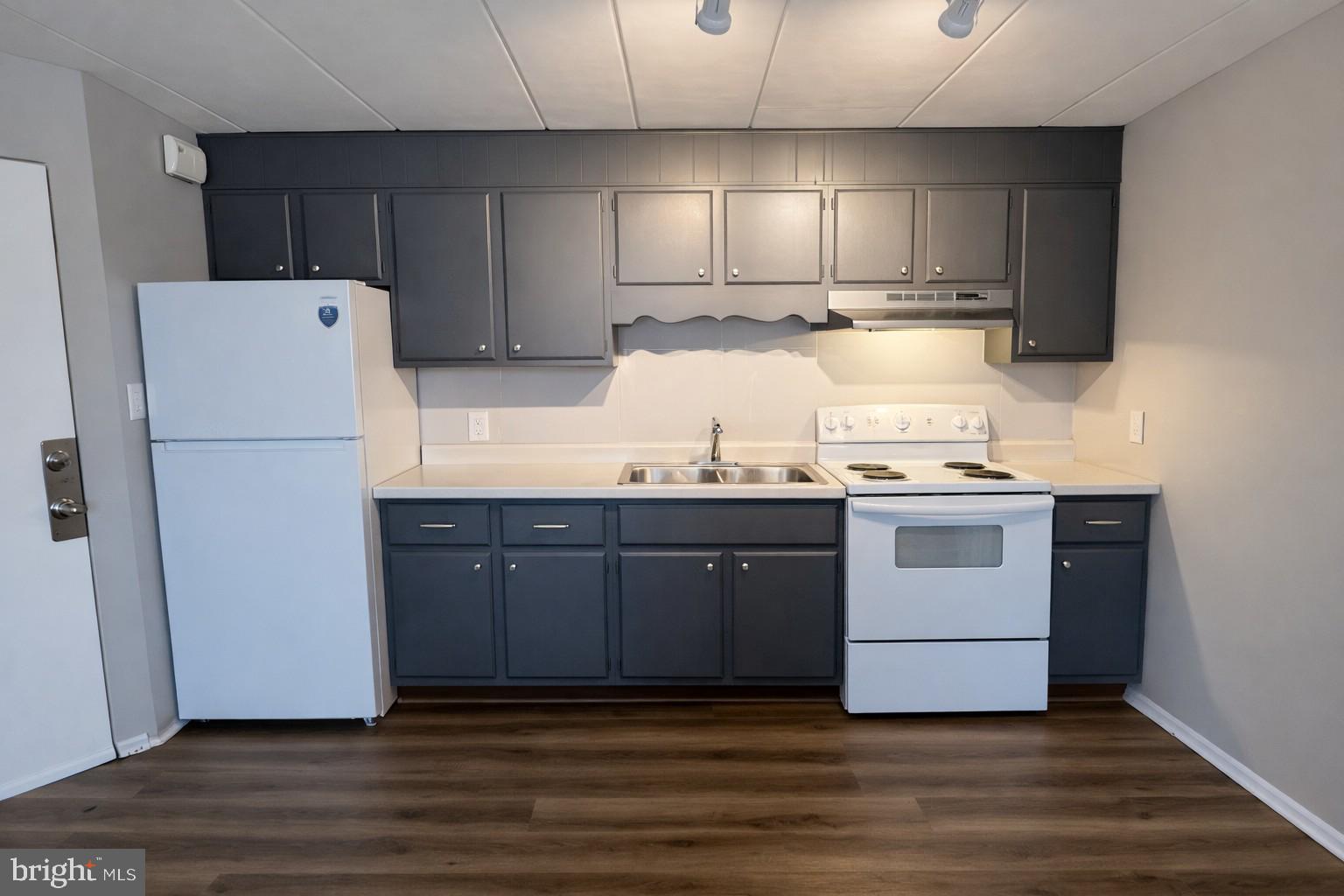 a kitchen with a refrigerator sink and cabinets