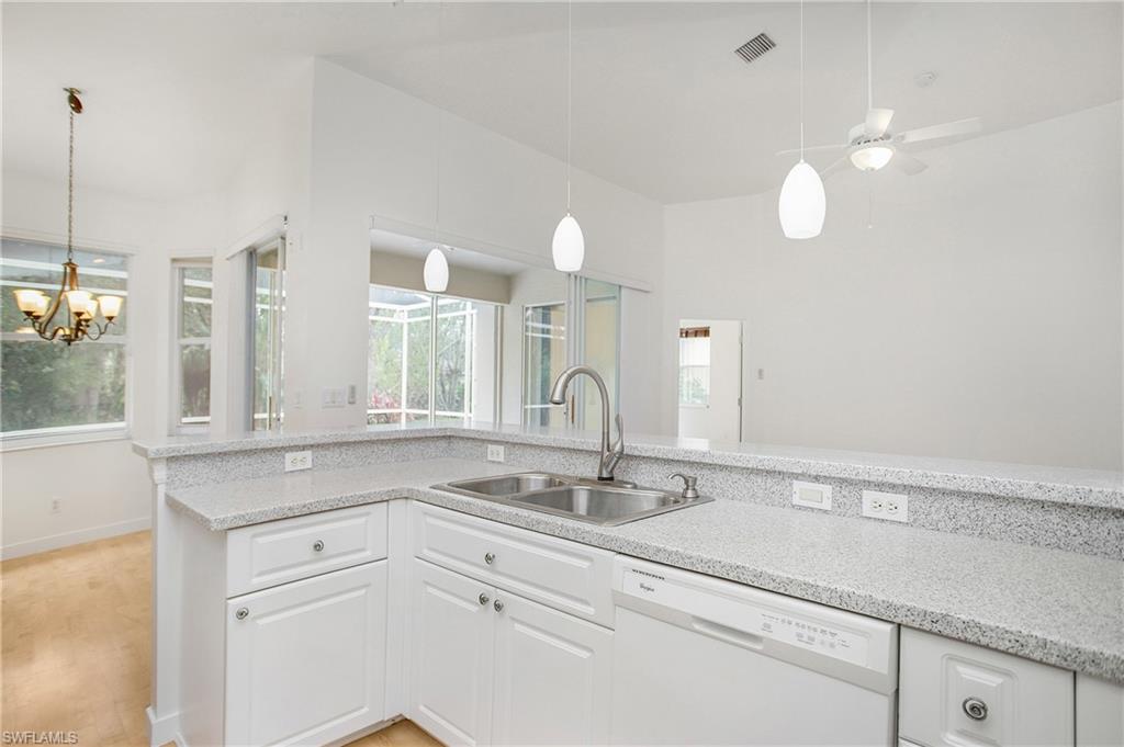 20951 Rivers Ford Estero, FL 33928 - Photo 18 of 49 a white kitchen with a sink and chandelier
