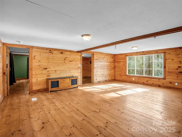 a view of an empty room with a fireplace and a window
