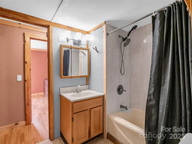 a bathroom with a tub sink and mirror