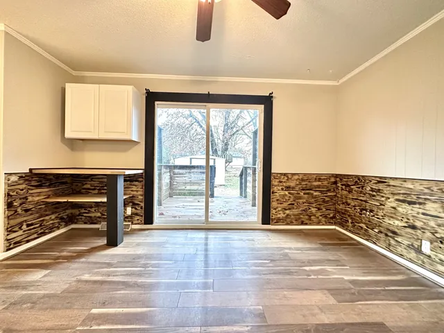 an empty room with a ceiling fan and window