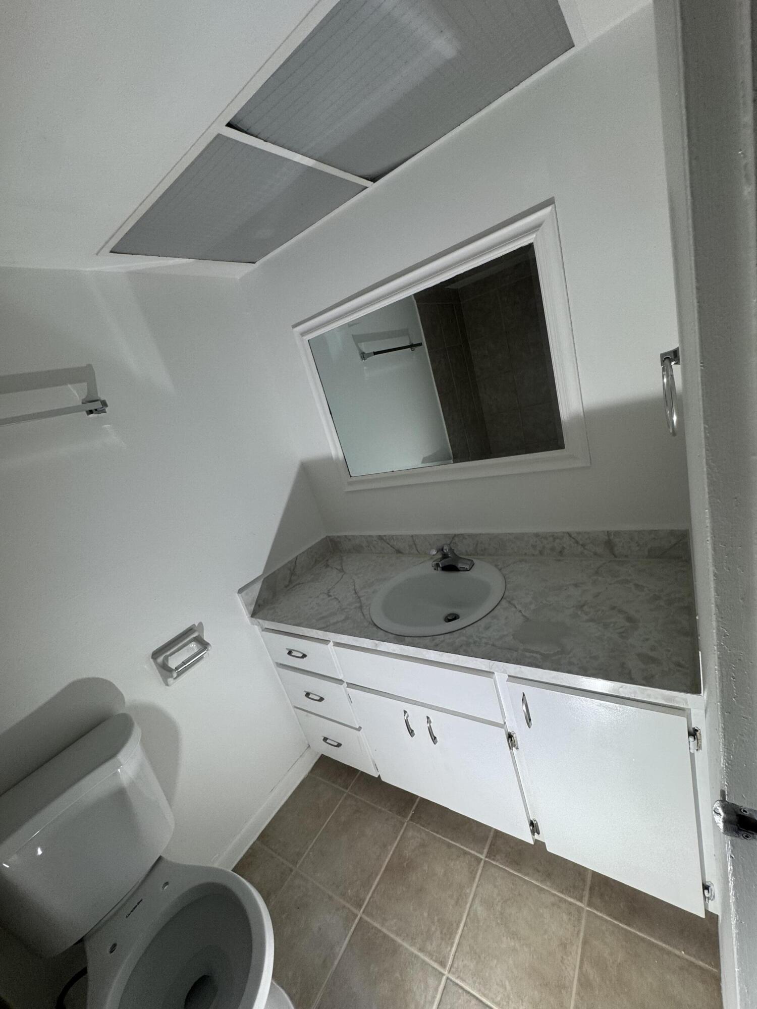 4429 Melvin Road, Unit A Lake Worth Beach, FL 33461 - Photo 15 of 20 a bathroom with a sink and a mirror