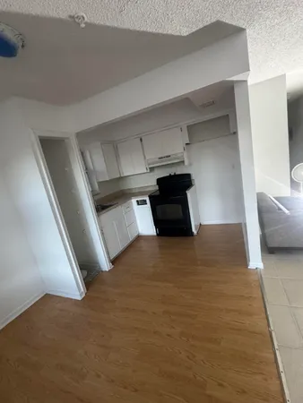 a view of a kitchen with a sink and a refrigerator