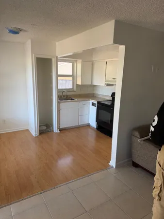 a view of an empty room with window and cabinet area