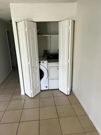 a view of an empty room with closet and wooden floor