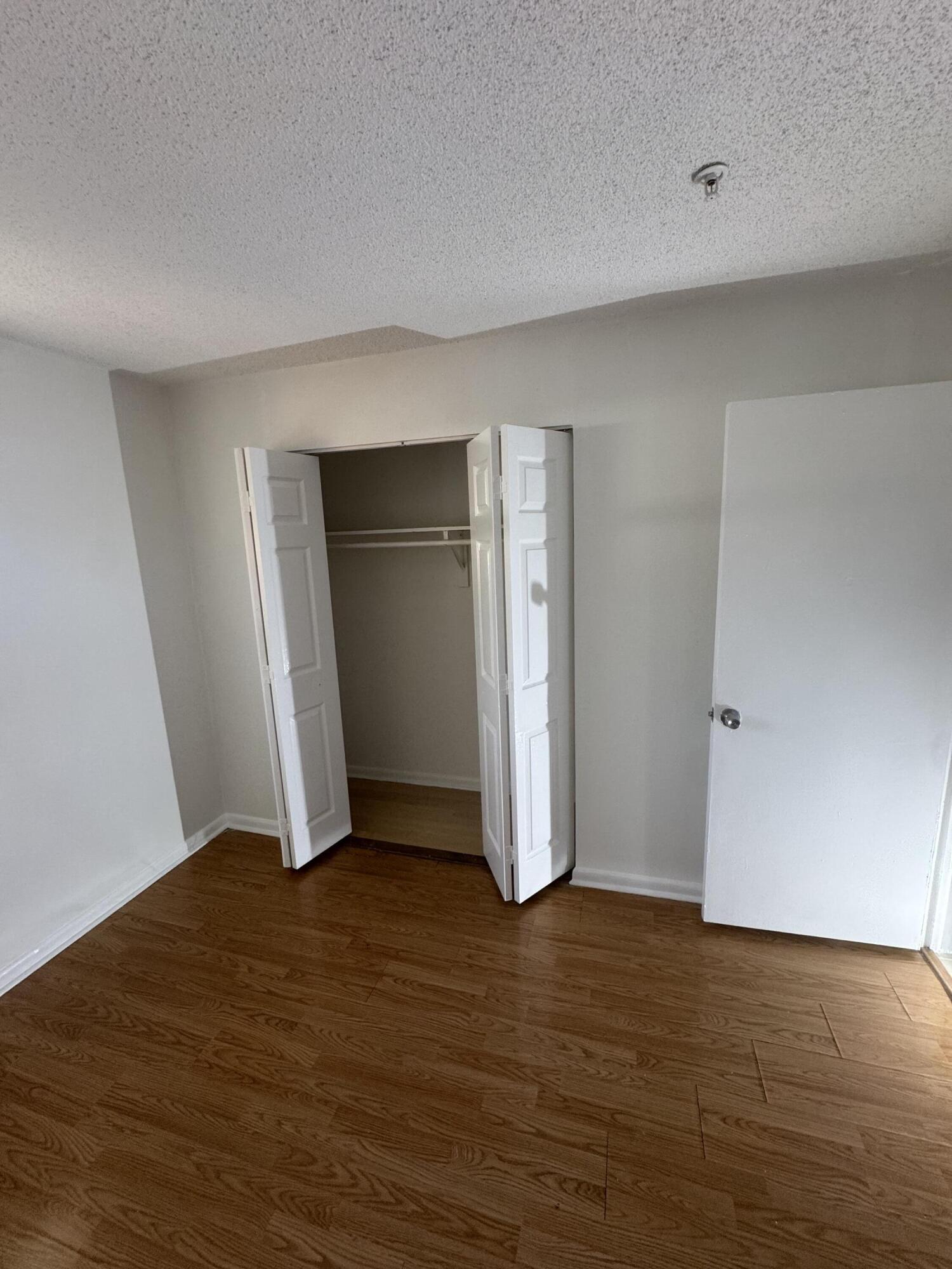 4429 Melvin Road, Unit A Lake Worth Beach, FL 33461 - Photo 10 of 20 a view of an empty room with closet and wooden floor