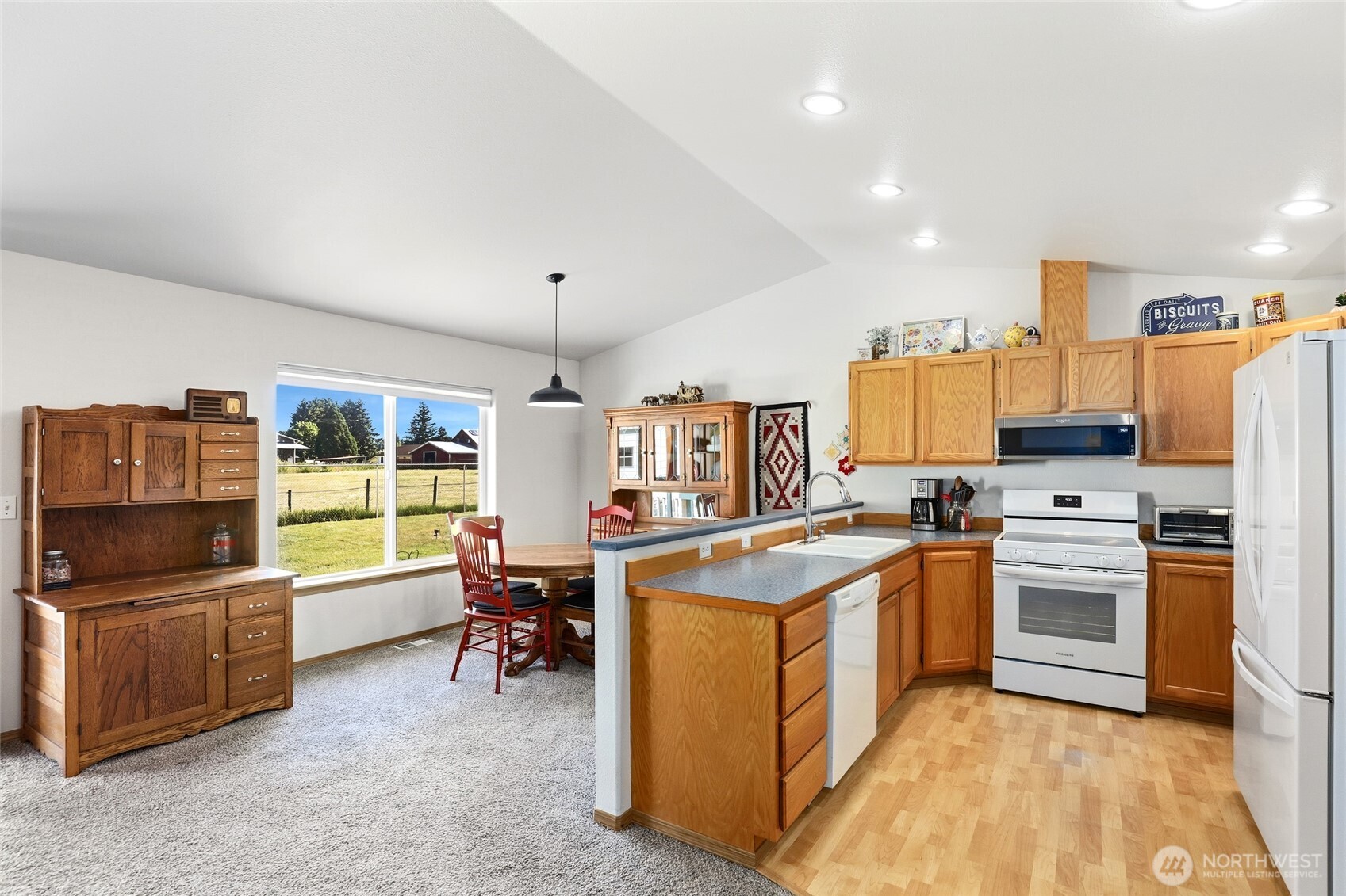 8008 188th Avenue Southwest Rochester, WA 98579 - Photo 14 of 40 a kitchen with stainless steel appliances granite countertop a stove top oven a sink dishwasher a dining table and chairs with wooden floor