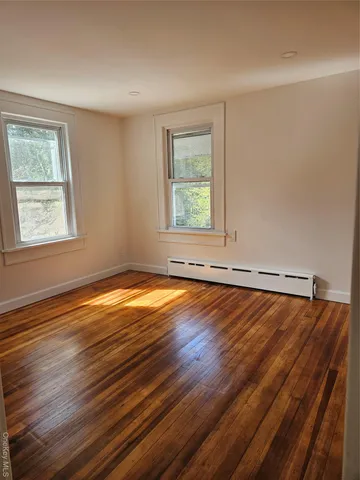 a view of a room with wooden floor and window