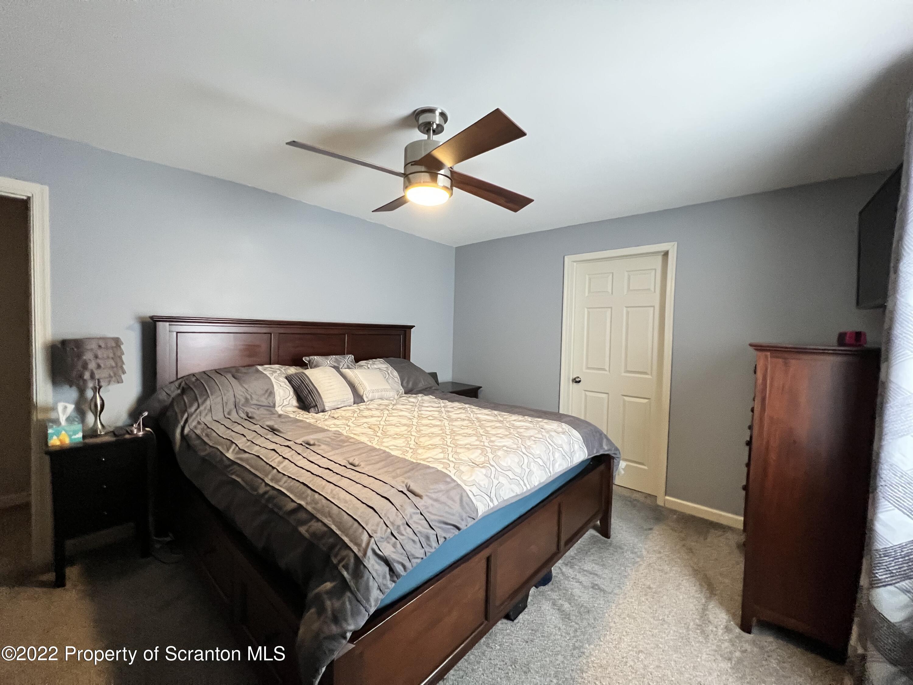 897 Scott Road Dickson City, PA 18519 - Photo 11 of 18 a bedroom with a bed and a lamp
