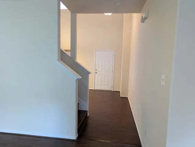 a view of a hallway with wooden floor and staircase