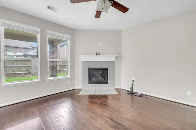 wooden floor fireplace and windows in an empty room