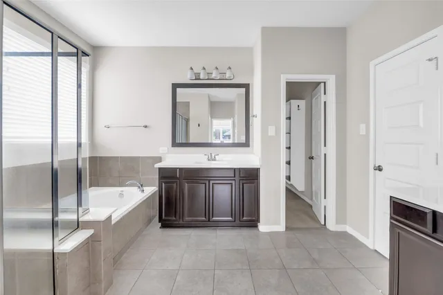 a bathroom with a tub sink and a mirror