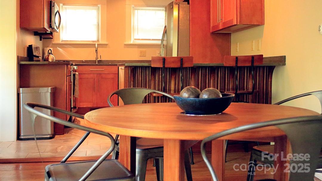 10 Coleman Avenue Asheville, NC 28801 - Photo 5 of 13 a kitchen with a table chairs and a refrigerator