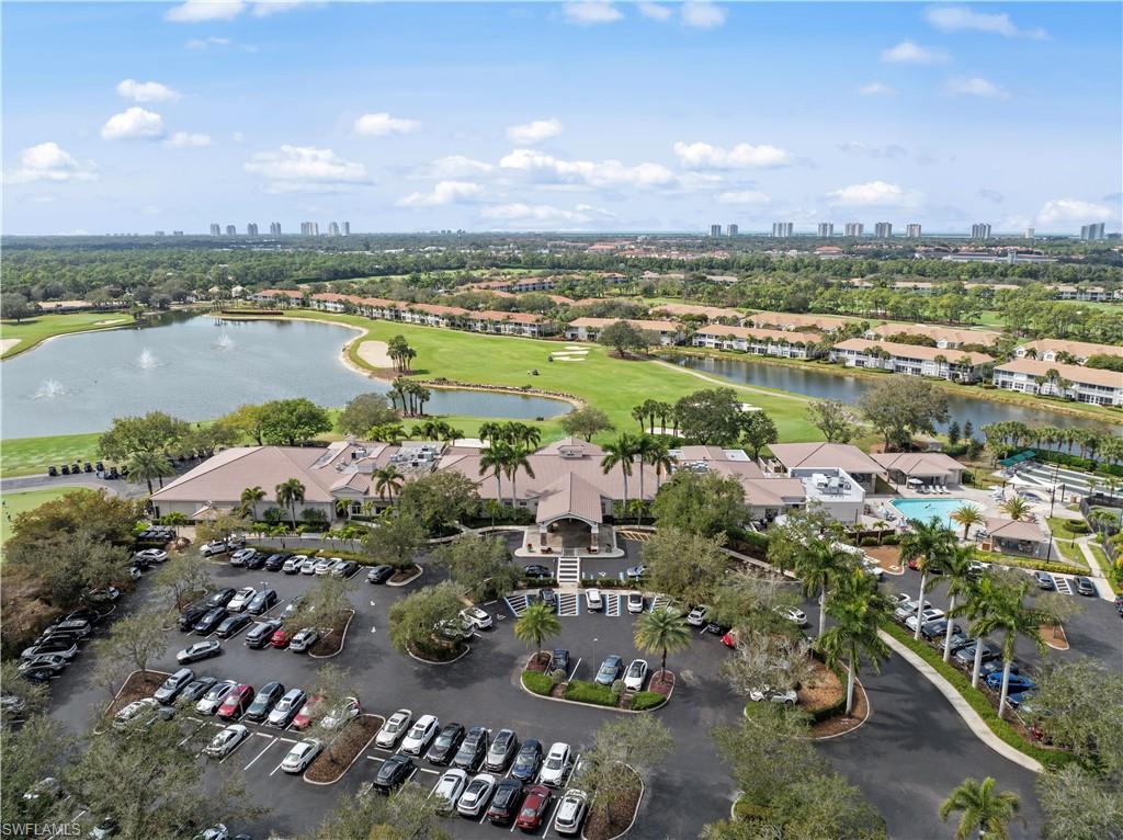9331 Spring Run Boulevard, Unit 3005 Estero, FL 34135 - Photo 41 of 48 Expansive golf course with multiple water features, clubhouse with covered entry, large outdoor pool, and surrounding residential buildings