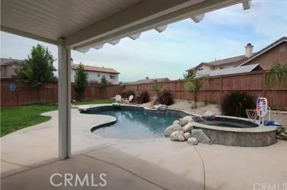 a backyard of a house with fireplace table and sofas