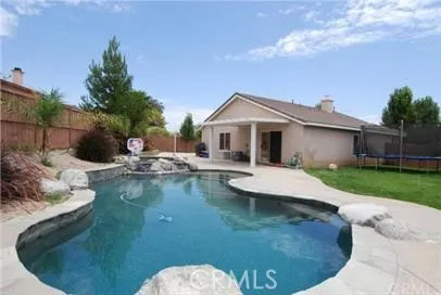 a view of a house with pool plants and large trees