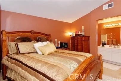 a bedroom with a large bed and a chandelier